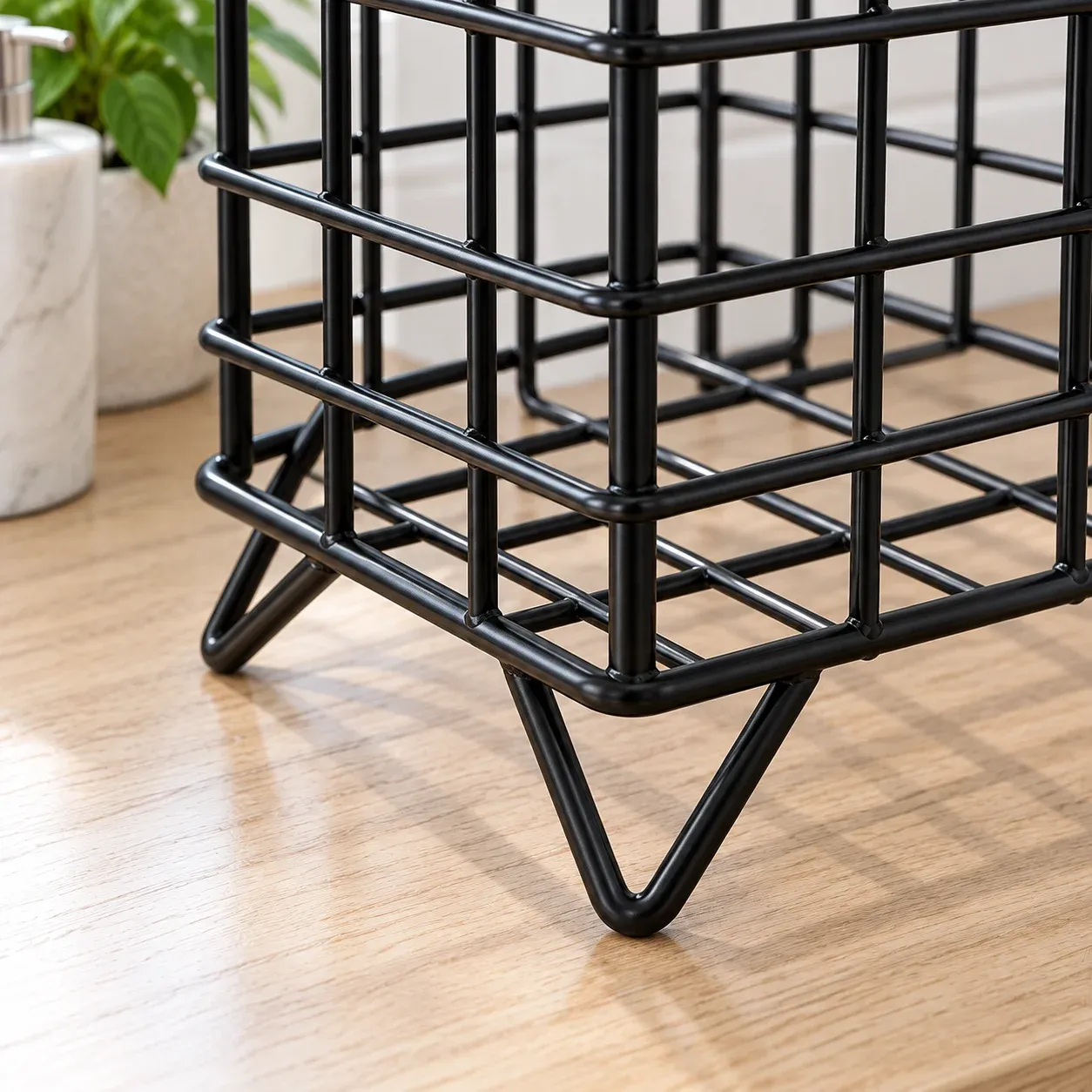 Close view of black wire grid joins and bent-wire foot